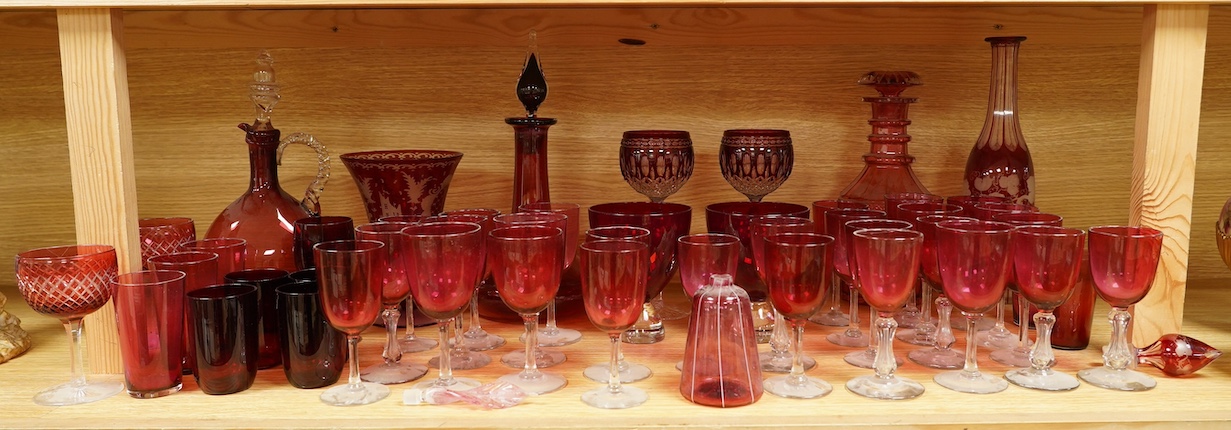 A collection of Victorian cranberry glassware to include decanters, flashed glass goblets and vases, largest 32cm high. Condition - mostly fair